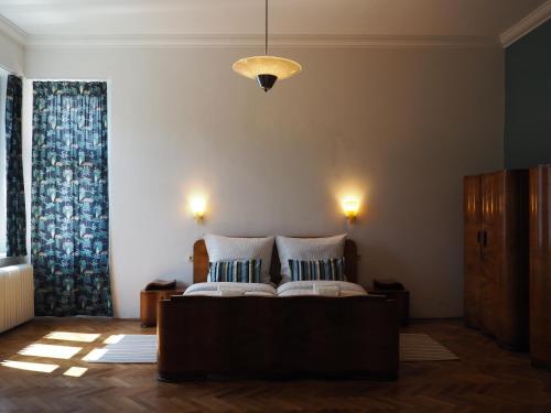 1 dormitorio con 2 camas y lámpara de araña en Učiteľov - The teachers house en Liptovský Mikuláš