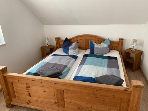 a bedroom with a wooden bed with blue and white pillows at Apartment 4 - Gourmetzimmer in Bestensee