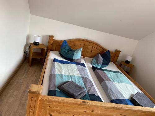 a wooden bed with two pillows on top of it at Apartment 5 - Gourmetzimmer in Bestensee