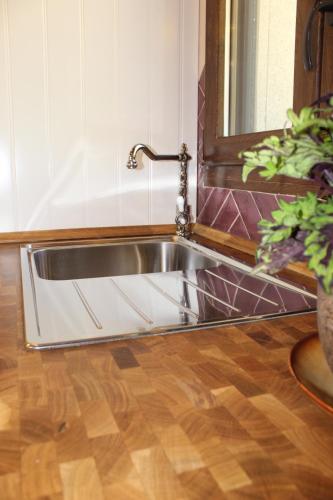 a stainless steel sink in a bathroom with a mirror at Alojamiento Turístico La alegría de la huerta in Cepeda