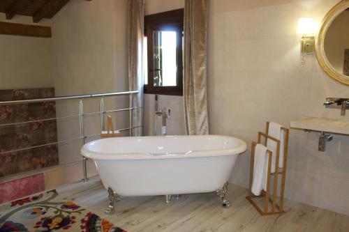a white bath tub in a bathroom with a mirror at Alojamiento Turístico La alegría de la huerta in Cepeda