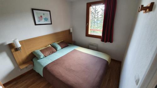 a small bedroom with a bed and a window at Appartement 3 étoiles 6 personnes les Orres 1800 in Les Orres