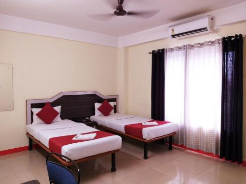 um quarto de hotel com duas camas e uma janela em HOTEL NILADRII GALAXY em Siliguri