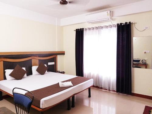 um quarto com uma cama e uma janela em HOTEL NILADRII GALAXY em Siliguri