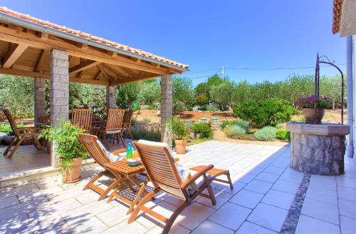 a patio with rocking chairs and a wooden gazebo at Holiday Home Lavanda in Kornić