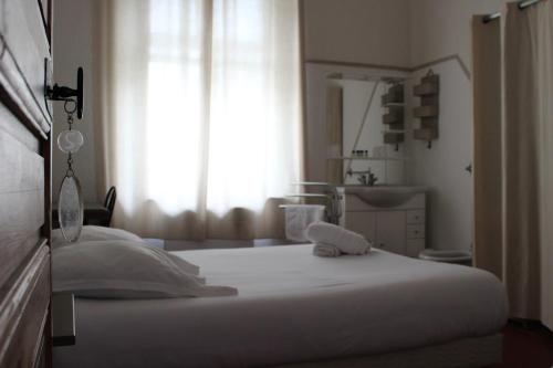 a bedroom with a white bed and a window at Les saladelles in Salin-de-Giraud