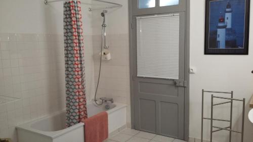 a bathroom with a tub and a shower with a door at Le gîte blinois in Blain