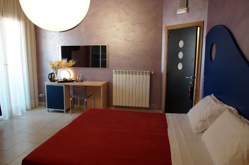 a bedroom with a bed and a desk and a table at B&B Alixia in Alezio