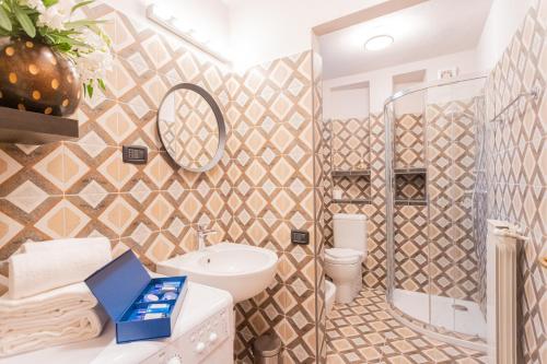 łazienka z umywalką, toaletą i lustrem w obiekcie Villa Castello with jacuzzi & priceless view by Rent All Como w mieście Argegno