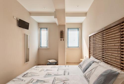 a bedroom with a bed with a wooden headboard at Le Tre More in Giardini Naxos