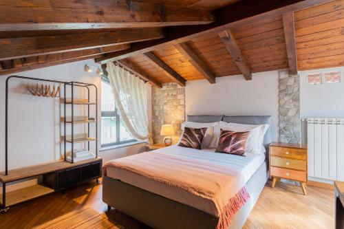 una camera con letto in una stanza con soffitti in legno di Villa Castello with jacuzzi & priceless view by Rent All Como ad Argegno