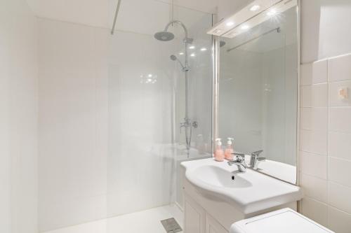 une salle de bain blanche avec un lavabo et une douche dans l'établissement Le Phare par Dodo-a-Cassis, à Cassis