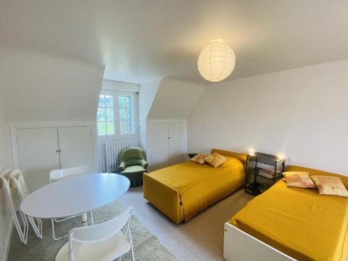 - une chambre avec 2 lits, une table et une salle à manger dans l'établissement TUMULUS - Villa 6 pièces, Jardin et Terrasse - S23, à Carnac
