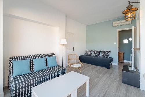 ein Wohnzimmer mit einem Sofa und einem Tisch in der Unterkunft Le Phare par Dodo-a-Cassis in Cassis