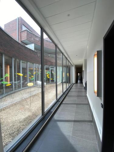an empty hallway with windows in a building at Hotel De Boskar Peer in Peer