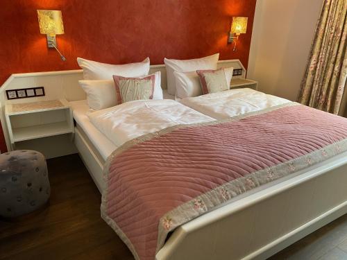 a bedroom with a large bed with white sheets and pillows at Hotel Alte Posthalterei in Creuzburg