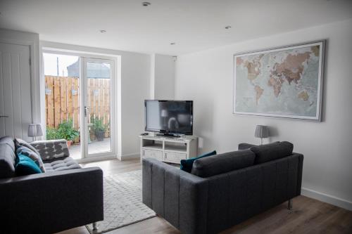 a living room with two couches and a tv at The Old Bakery in Gateshead