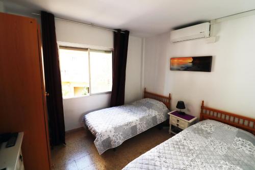 a bedroom with two beds and a window at Apartment 2 bedrooms, 250m Levante beach in Benidorm