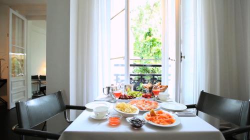 a table with food on it with a window at Aussen Alster Hotel in Hamburg