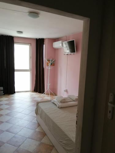 um quarto com uma cama e uma televisão na parede em Пай Хост em Plovdiv
