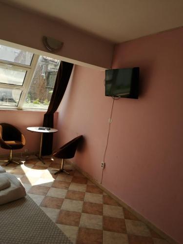 a room with a tv on the corner of a wall at Пай Хост in Plovdiv