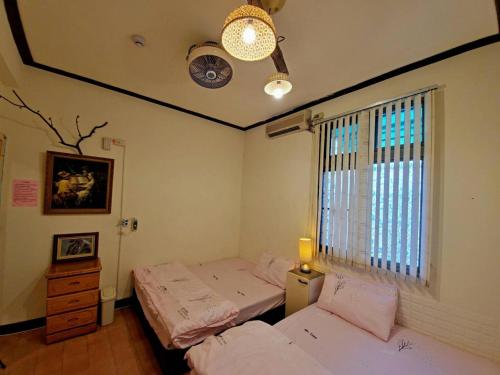 2 camas individuais num quarto com uma janela em Xincun Seed Homestay em Anping