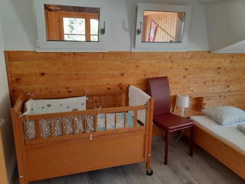 a bedroom with a bunk bed and a chair and two windows at Berner Oberland in Därligen