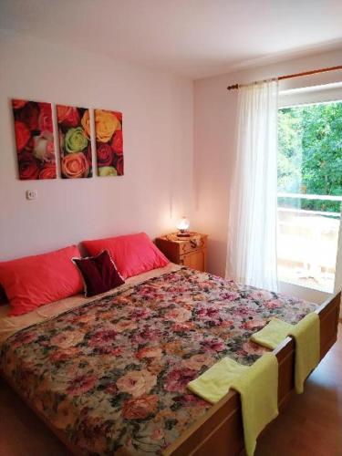 a bedroom with a large bed and a window at APARTMANI INES RABAC in Rabac