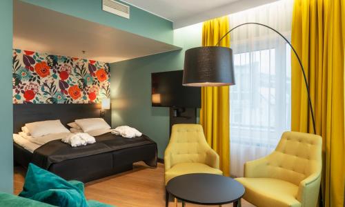 1 dormitorio con 1 cama, mesa y sillas en Thon Hotel Harstad, en Harstad