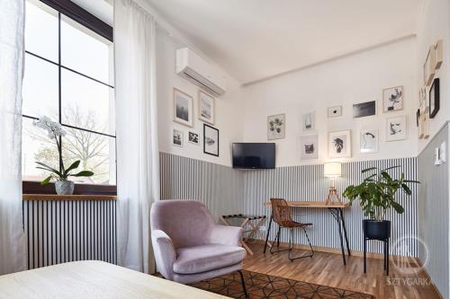a bedroom with a chair and a desk and a window at Sztygarka. Pensjonat Pod Wieżą Katowice Chorzów in Chorzów