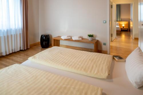a hotel room with two beds and a bathroom at Recknitztal-Hotel Marlow in Marlow