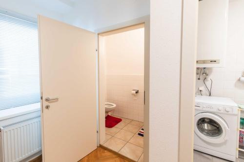 ein Badezimmer mit einer Waschmaschine und einer Waschmaschine in der Unterkunft Ferienwohnung St. Pölten Rathausplatz in Sankt Pölten