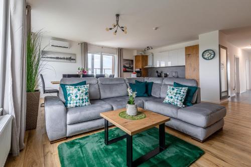 a living room with a couch and a table at Symphony Baltica Towers Apartamenty in Gdańsk