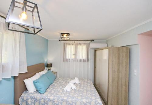 una piccola camera da letto con un letto con un orsacchiotto sopra di Panos House a Kinira