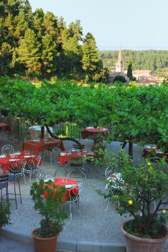 a patio with tables and chairs and a bunch of trees at Auberge de la Tour de Brison in Sanilhac