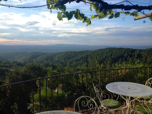 a table and chairs on a balcony with a view at Auberge de la Tour de Brison in Sanilhac