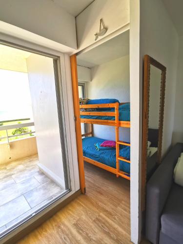 Cette chambre comprend 2 lits superposés et une porte coulissante en verre. dans l'établissement Appartement climatise Vue Mer 208, à Canet
