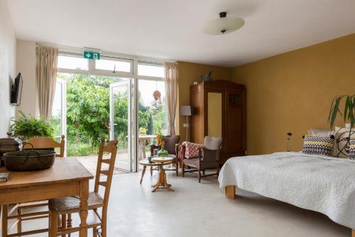 a bedroom with a bed and a table and chairs at De Nieuwe Warande in Tilburg