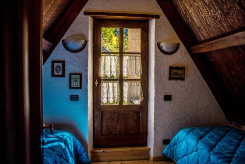 Alpeggio Pruno في Corfino: غرفة فيها باب وسرير ونافذة