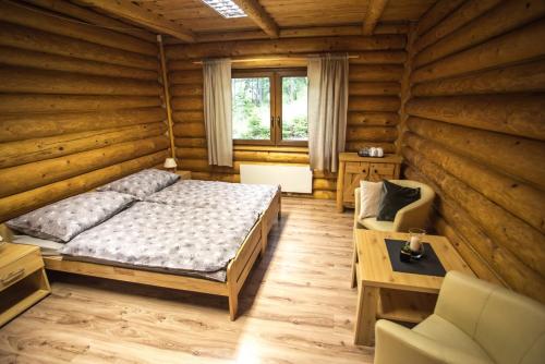 a bedroom with a bed and a couch and a table at Ubytovanie Dobšinská Ľadová Jaskyňa in Stratená
