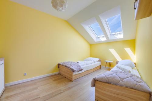 a attic bedroom with two beds and a window at Dwie Sosny z sauną, Sun & Snow in Ustronie Morskie