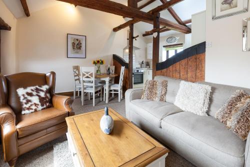 a living room with a couch and a table at Skipbridge Farm Cottages in Green Hammerton