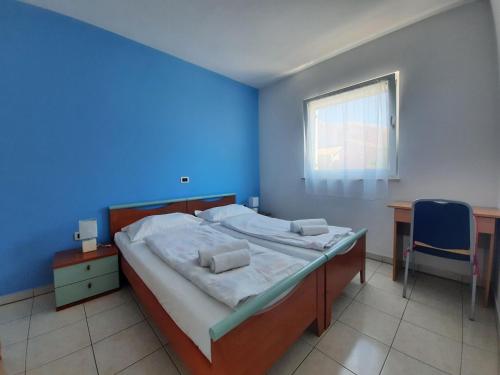 a bedroom with a large bed with a blue wall at Villa Doris YourCroatiaHoliday in Premantura