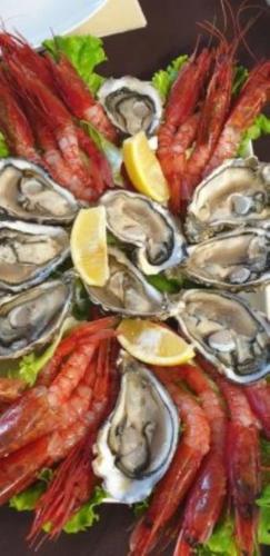 a plate of oysters and shrimp with lemons and lettuce at Hotel Sant'Ilario in Rovereto