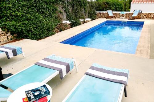 una piscina con 2 tumbonas y una piscina en San Colomban en Sant Lluis