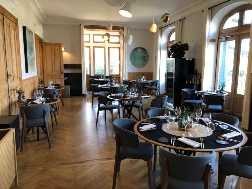 Saint-Paul-en-JarezにあるEclosion Château Hôtel & Restaurantのテーブルと椅子が備わるレストラン