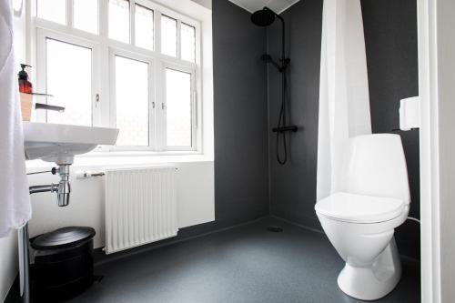 a bathroom with a toilet and a sink and a window at Diagonalkroen in Give