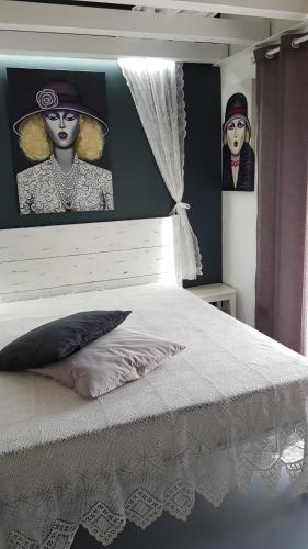um quarto com uma cama com duas fotografias na parede em Il Museo di Teresa piazza del Teatro em Agrigento