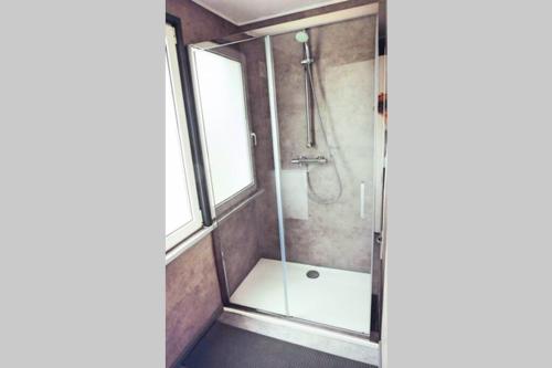 La salle de bains est pourvue d'une douche avec une porte en verre. dans l'établissement Chez Sarah, à Stavelot
