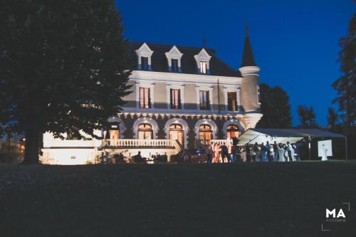 a large building with people standing in front of it at Eclosion Château Hôtel & Restaurant in Saint-Paul-en-Jarez